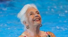 Dame die geniet van zwemmen in het doelgroepenbad.