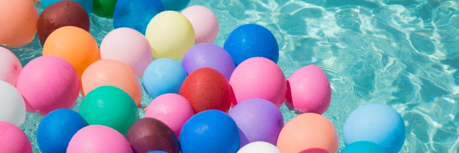 Gekleurde ballonnen liggen in het zwembadwater