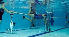 3 onderwaterfietsen waar mensen naast zwemmen