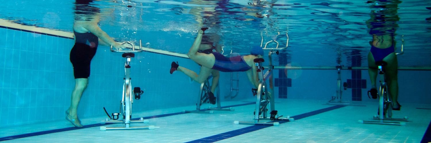 3 onderwaterfietsen waar mensen naast zwemmen