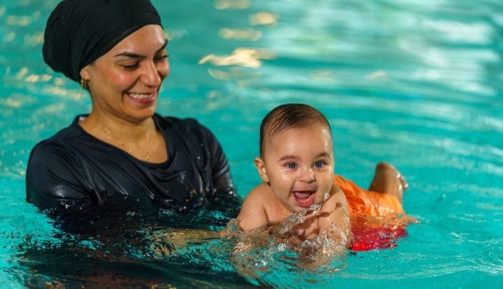 vrouw in burkini zwemmen met zoon