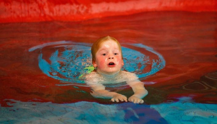 kind zwemt door het gat