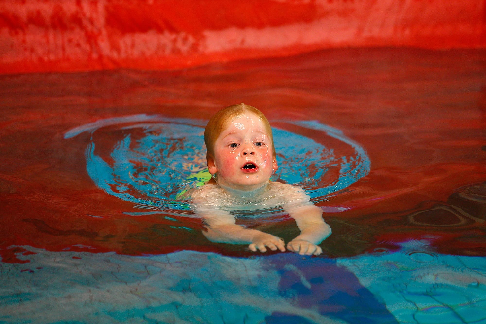 kind zwemt door het gat