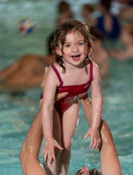 Meisje zwemt met vader